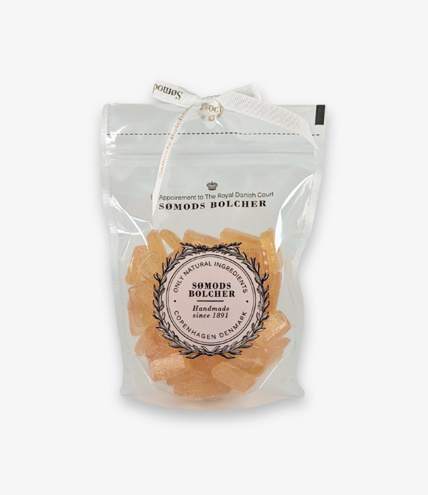 A 250 g bag of Sømods Bolcher honey candies – golden, clear candies in a transparent bag, adorned with the logo and an elegant ribbon.