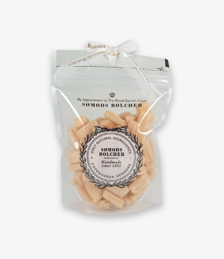 En 250 g pose med Sømods Bolchers krydderhonningbolcher – gyldne og lysebrune bolcher i en gennemsigtig pose med logo og genluk.